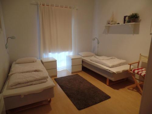 Cette petite chambre comprend 2 lits et une fenêtre. dans l'établissement Strandpark Sierksdorf H057, à Sierksdorf