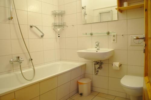 La salle de bains est pourvue d'un lavabo, d'une baignoire et de toilettes. dans l'établissement Strandpark Sierksdorf H057, à Sierksdorf