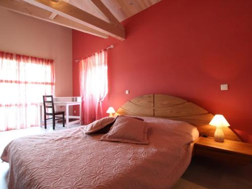 - une chambre dotée d'un lit avec un mur rouge dans l'établissement Gîte Saint-Just-prés-Brioude, 4 pièces, 6 personnes - FR-1-582-231, à Saint-Just-près-Brioude