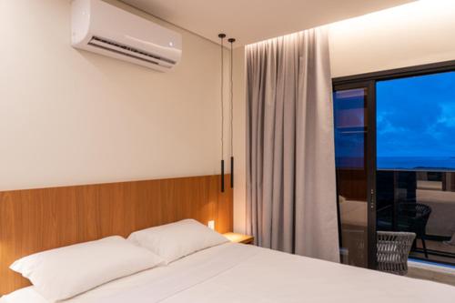 a bedroom with a white bed and a window at Salinas Premium Resort in Salinópolis