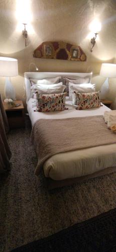 a bedroom with a bed with pillows and two lamps at Candelaria House Boutique in Bogotá