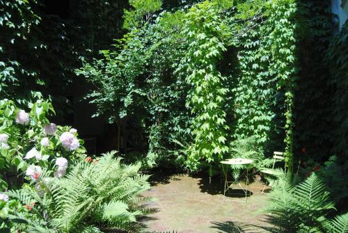 a garden with plants and a table and chairs at Apartments Casa nel Verde in Rocchetta Tanaro