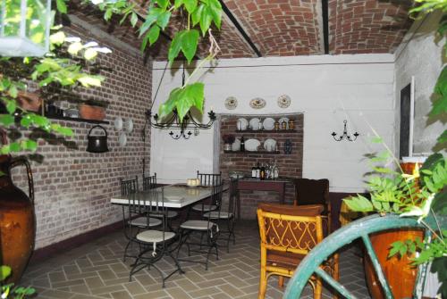 a patio with a table and chairs in a room at Apartments Casa nel Verde in Rocchetta Tanaro