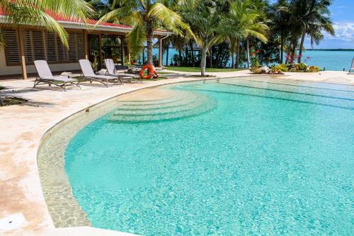 a swimming pool with chairs and the ocean in the background at Villa Marcela in Calderitas