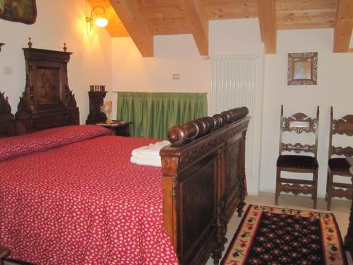 a bedroom with a wooden bed with a red bedspread at B&B La Gerla Blu in Tolmezzo
