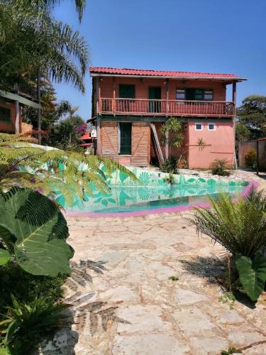 a house with a swimming pool in front of a house at Cabañas Los Achicuales in Cuetzalán del Progreso