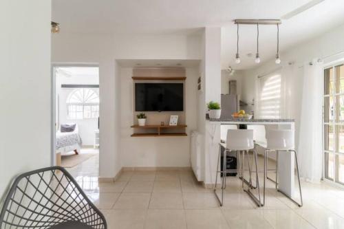 a kitchen with white walls and a table and chairs at Cozy 2 bdr condo, with pool area and free WIFI in Punta Cana