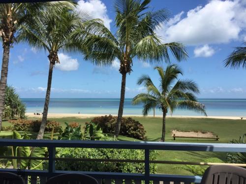 uitzicht vanaf het balkon van een resort met palmbomen bij Villa 20 in Tangalooma