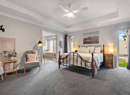 um quarto com uma cama e uma ventoinha de tecto em Wine Down Manor em Cessnock