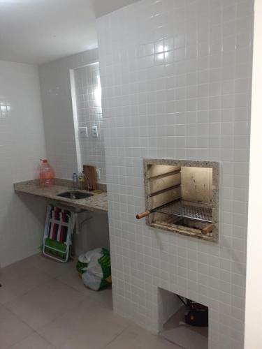 ein Badezimmer mit einem Waschbecken und einer gefliesten Wand in der Unterkunft Apartamento com vista pro mar in Bertioga