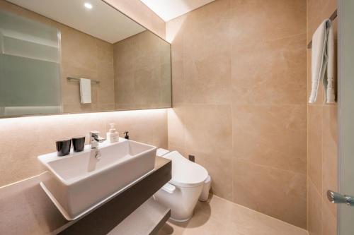 a bathroom with a sink and a toilet at Hotel Foret The Spa in Busan