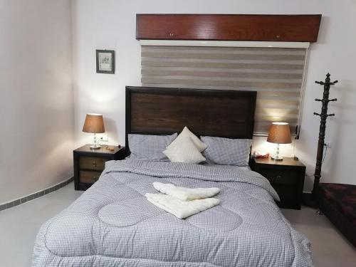 - une chambre avec un grand lit et 2 serviettes dans l'établissement Jasmine's House, à Jerash