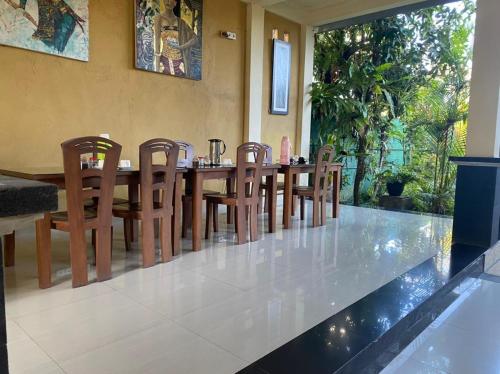 een eetkamer met een houten tafel en stoelen bij Secret Garden Sky in Ubud