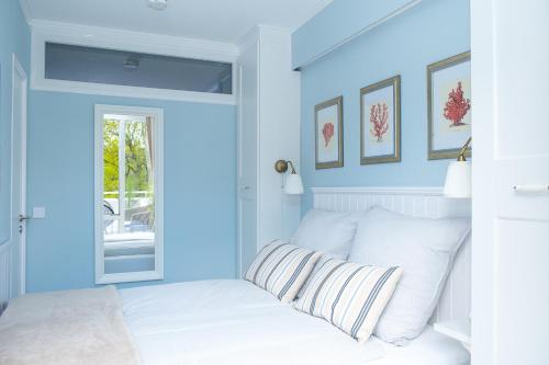 a bedroom with blue walls and a bed with white pillows at Panoramic App C03-4 Sonnendeck in Sierksdorf