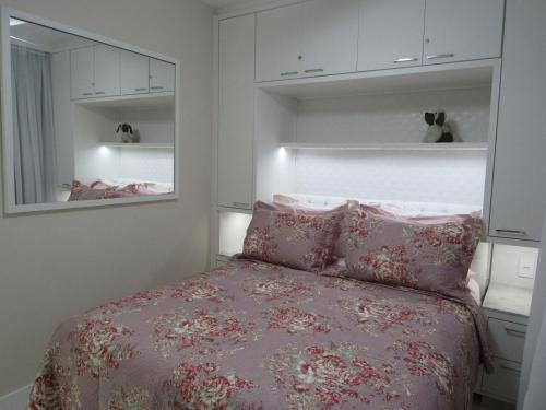 um quarto com uma cama com lençóis e almofadas cor-de-rosa em AP 507 UMA QUADRA DO MAR no Balneário Camboriú