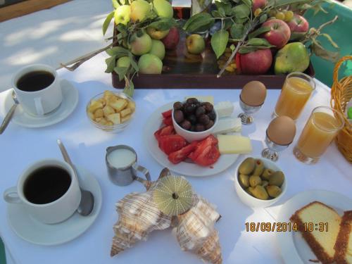 a table topped with plates of food and cups of coffee at Marilena in Skala Eresou
