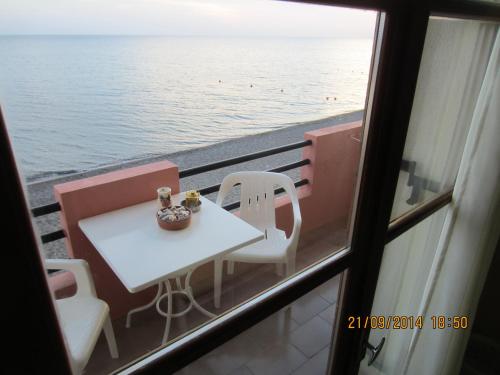 a table and chairs on a balcony with the ocean at Marilena in Skala Eresou