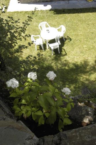 a table and chairs in a yard with flowers at Hotel Rural El Portón de Murillo in Broto