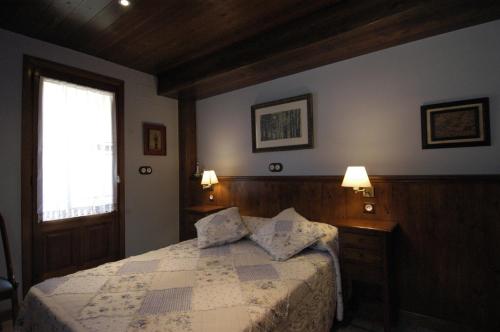 a bedroom with a bed with two pillows on it at Hotel Rural El Portón de Murillo in Broto