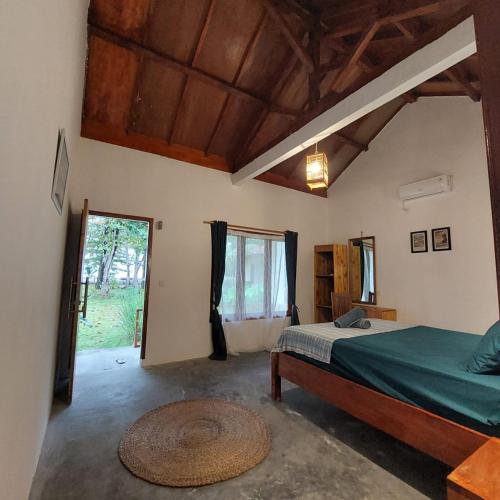 a bedroom with a bed and a large window at Kambuna Bungalow in Krui