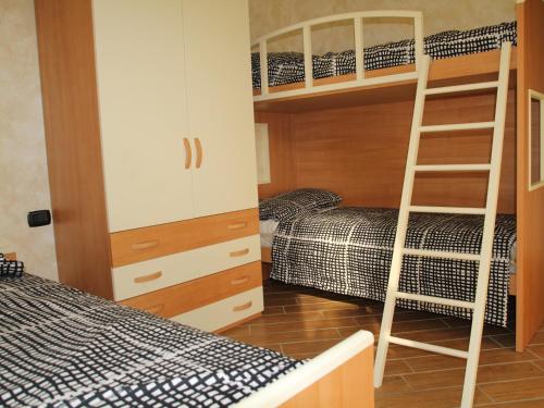Zimmer mit Etagenbett, 2 Betten und einer Leiter in der Unterkunft Agriturismo Il Sorriso dei Figli in Argegno