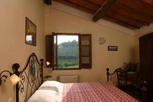 Schlafzimmer mit einem Bett und einem Fenster in der Unterkunft Agriturismo Il Sasso in Montepulciano