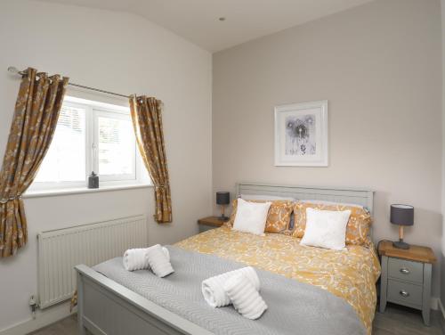 a bedroom with a bed with pillows and a window at Cosy Cottage in Menai Bridge