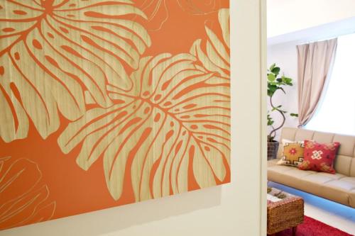 a living room with a painting of a palm leaf at ゆかるひ前島501 in Tomari