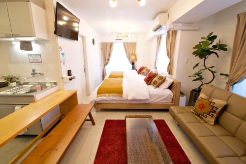 a small room with a bed and a couch at ゆかるひ前島501 in Tomari