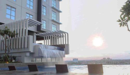 a rendering of a building with chairs in front of it at BeSS Mansion Hotel Surabaya in Wonocolo