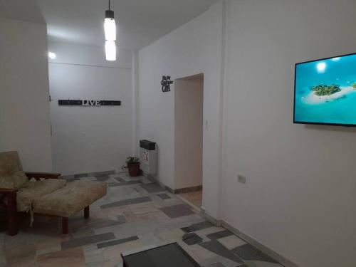 ein Wohnzimmer mit einem Sofa und einem TV an der Wand in der Unterkunft AmaNi Tigre. Confort estrategico in Tigre