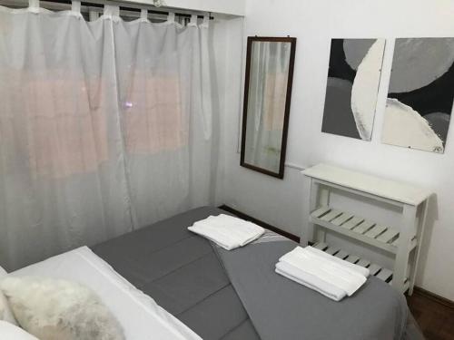 Habitación blanca con 2 camas y espejo. en AmaNi Tigre. Confort estrategico en Tigre
