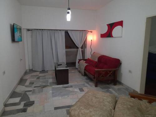 a living room with a couch and a red chair at AmaNi Tigre. Confort estrategico in Tigre