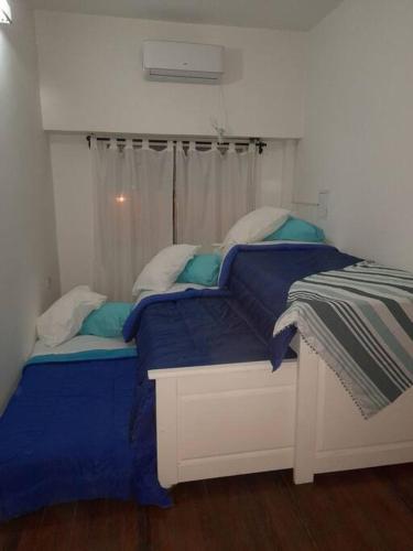 a bedroom with two beds with blue sheets and a window at AmaNi Tigre. Confort estrategico in Tigre