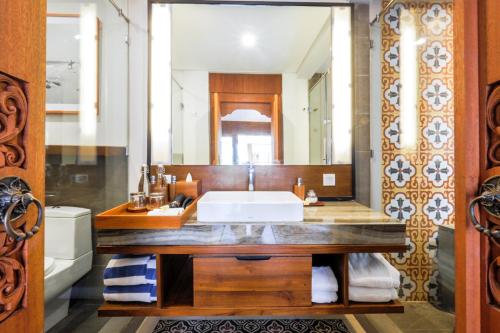 a bathroom with a sink and a large mirror at Sampatti Villas in Seminyak