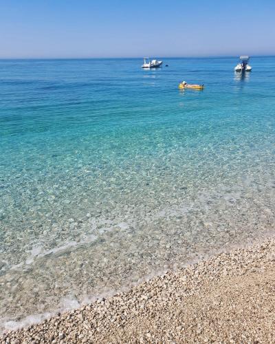 two boats in the water on a beach at Olea Residence, Luxury sea view apartment with private beach in Palasë