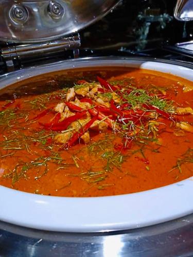 a bowl of soup with vegetables in a pot at Montana Hotel Songkhla in Songkhla