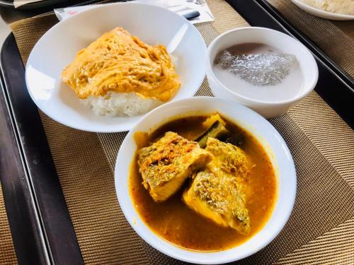 a table with two bowls of food and rice at Montana Hotel Songkhla in Songkhla