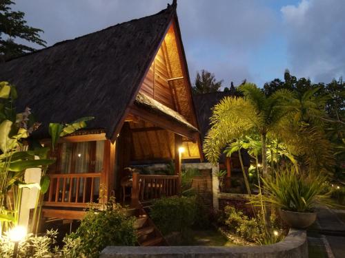 a house with a dark roof with lights on it at Cersen Resort Lombok in Kuta Lombok