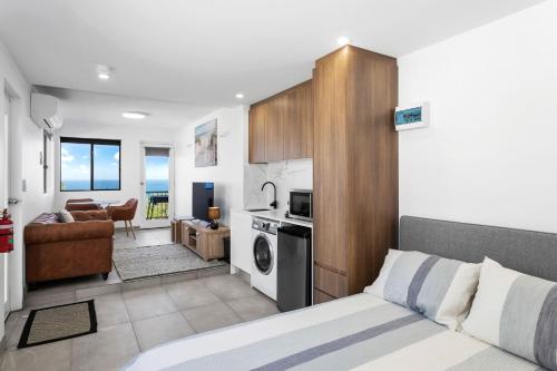 a bedroom with a bed and a living room at South Pacific Studio in Ulladulla