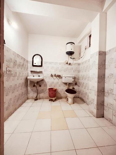 a bathroom with a toilet and a sink at Hotel Snow Mountain Mall Road in Manāli