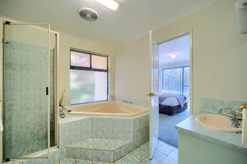 a bathroom with a tub and a sink at Bayside Villas in Walpole