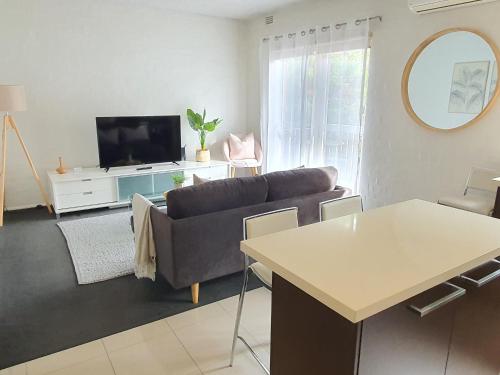 a living room with a couch and a tv at North Melbourne Retreat in Melbourne