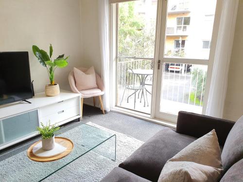 a living room with a couch and a tv at North Melbourne Retreat in Melbourne