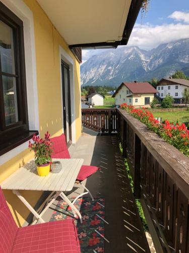 a balcony with a table and chairs and mountains at Haus Edeltraut in Bad Mitterndorf