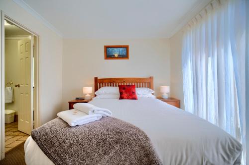 a bedroom with a large bed with two towels on it at Bayside Villas in Walpole