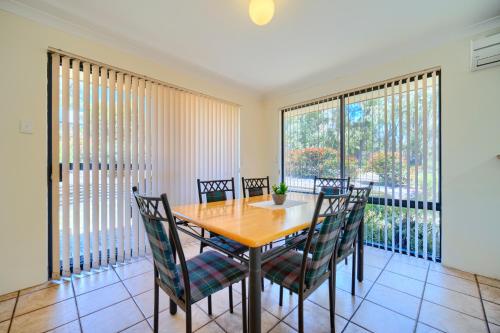 a dining room with a wooden table and chairs at Bayside Villas in Walpole