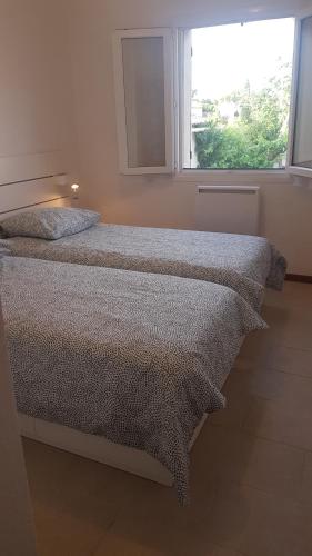 1 dormitorio con 2 camas y ventana en PROVENCE, SOLEIL ET LUBERON !!! Coin jardin 3 Lits 2 Chambres 80 m2 en Cheval-Blanc
