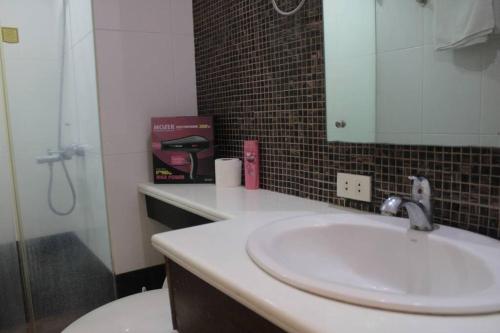 ein Badezimmer mit Waschbecken, Toilette und Spiegel in der Unterkunft A2J BGC Luxury 1BR Suite Near Burgos Circle & Mall in Manila