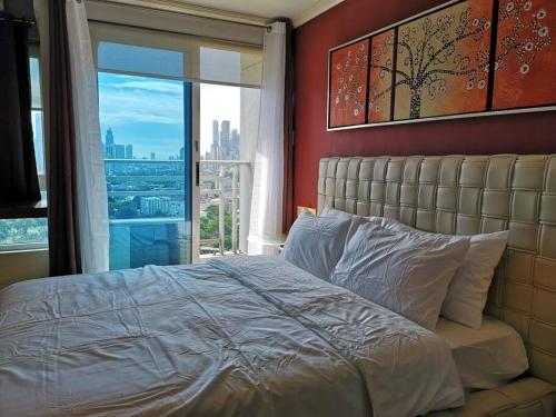 ein Schlafzimmer mit einem großen Bett und einem großen Fenster in der Unterkunft A2J BGC Luxury 1BR Suite Near Burgos Circle & Mall in Manila
